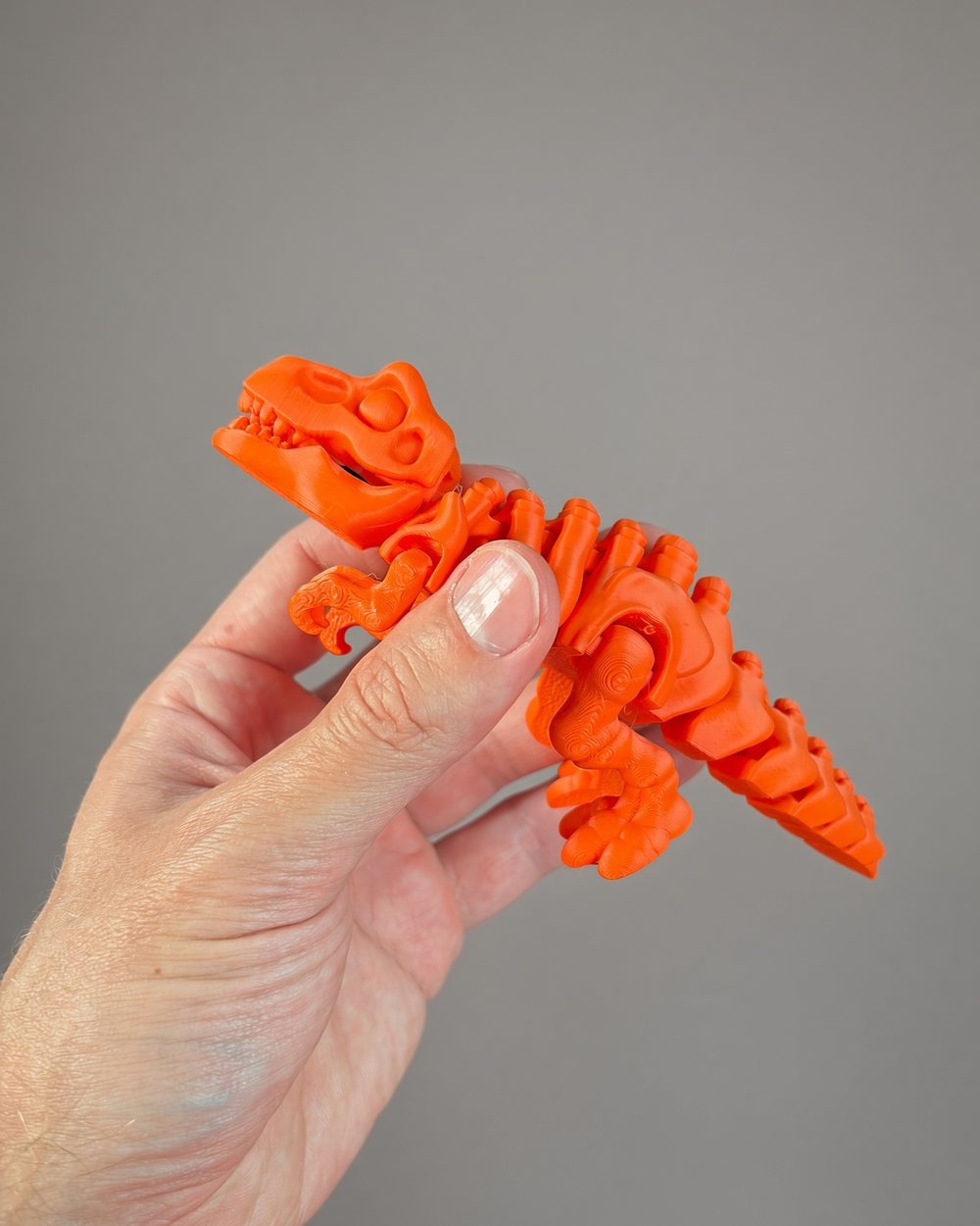 Khủng long T-rex màu cam có khớp cử động, nằm gọn trong tay